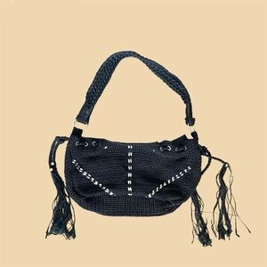 Black and white slouchy crochet shoulder bag with tassels and silver hardware